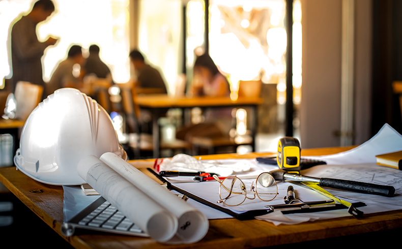 Profissionais revisando projeto na obra